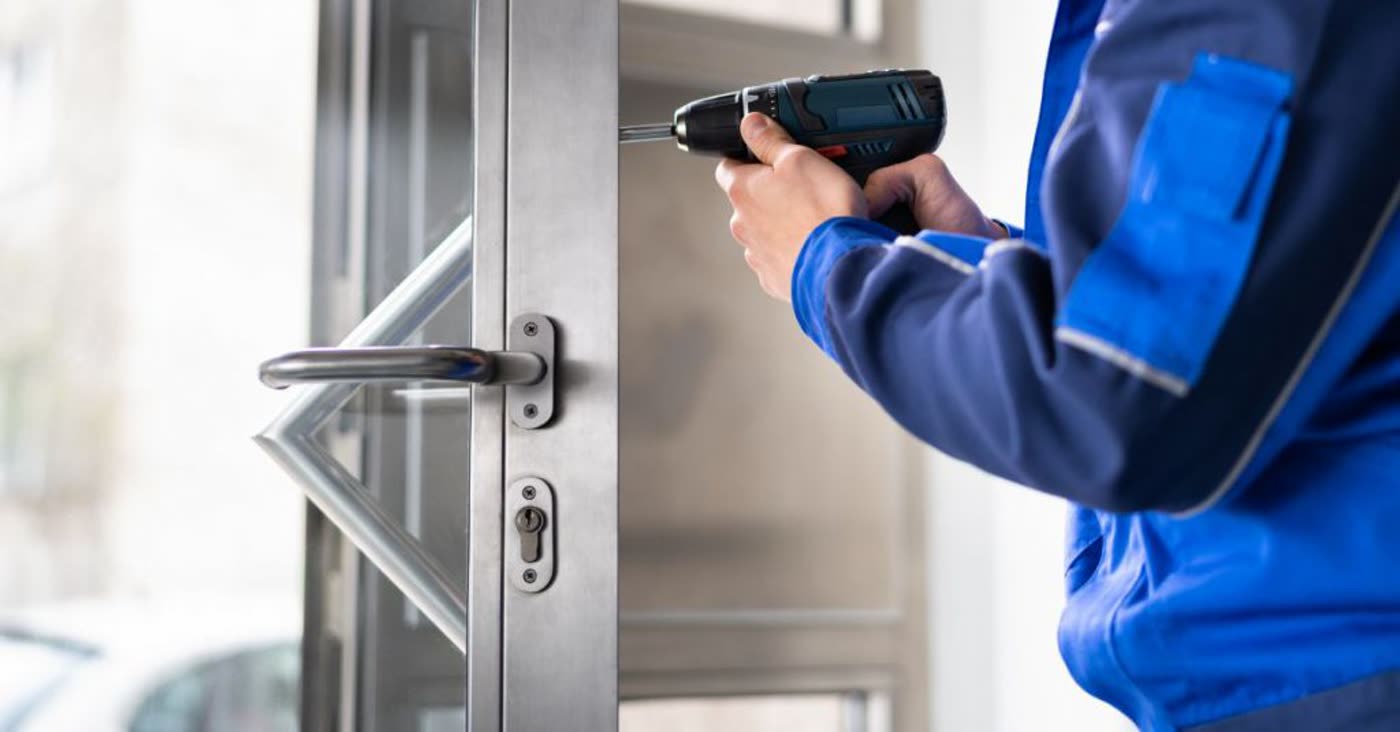 Locksmith installing a commercial door lock